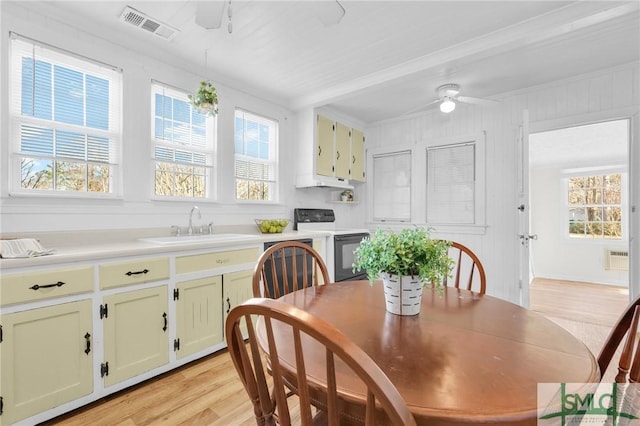 dining space with crown molding, light wood-type flooring, ceiling fan, and sink