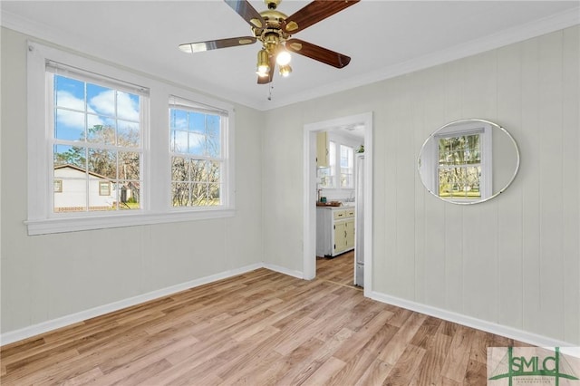 spare room featuring light wood-type flooring, crown molding, and ceiling fan