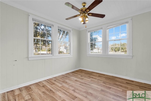 unfurnished room with ornamental molding, plenty of natural light, and light hardwood / wood-style flooring