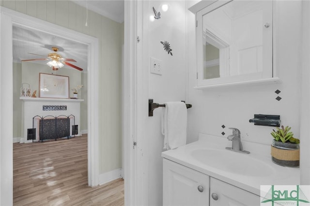 bathroom with ceiling fan, vanity, and wood-type flooring