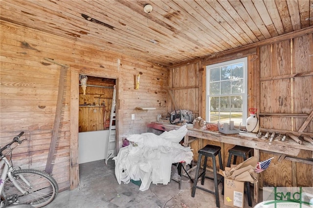 misc room featuring concrete flooring, wooden ceiling, and wood walls