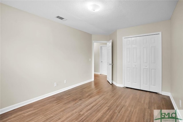 209 Mariners Way, Savannah, GA 31419 - unfurnished bedroom featuring wood finished floors, baseboards, a textured ceiling, and a closet