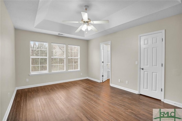 209 Mariners Way, Savannah, GA 31419 - spare room featuring dark wood-type flooring, baseboards, a ceiling fan, and a tray ceiling