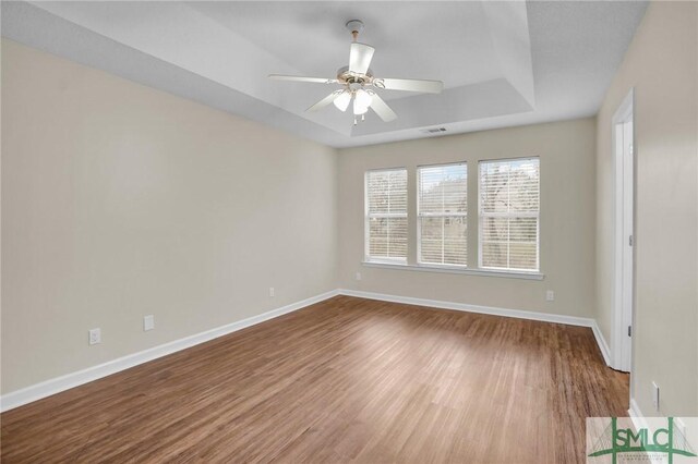209 Mariners Way, Savannah, GA 31419 - unfurnished room featuring a tray ceiling, wood finished floors, baseboards, and a ceiling fan