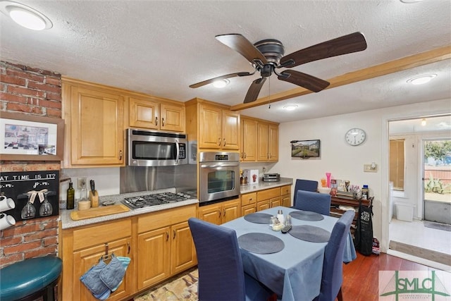 kitchen with light wood-type flooring, appliances with stainless steel finishes, a textured ceiling, and ceiling fan