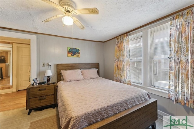 bedroom with light hardwood / wood-style floors, multiple windows, and a textured ceiling