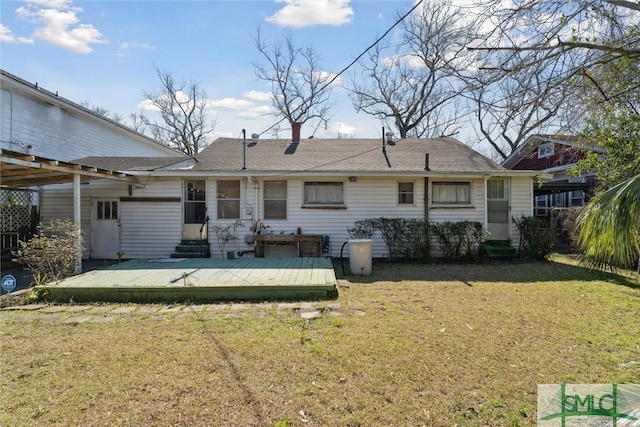 rear view of property featuring a deck and a lawn