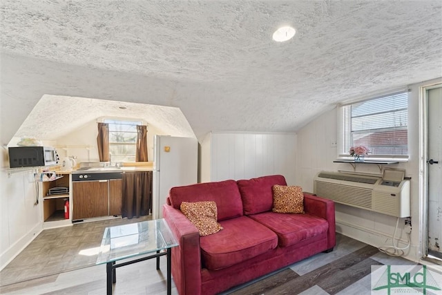 living room featuring a textured ceiling, light hardwood / wood-style floors, vaulted ceiling, and plenty of natural light