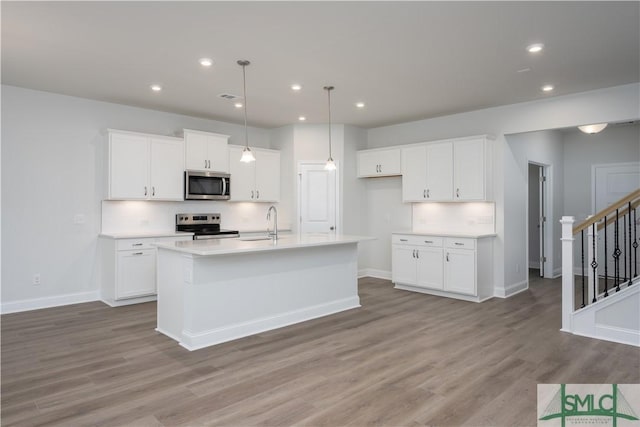 kitchen with appliances with stainless steel finishes, light wood-style flooring, and white cabinets