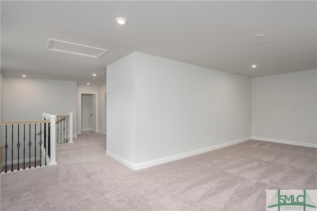 carpeted spare room with recessed lighting, attic access, and baseboards