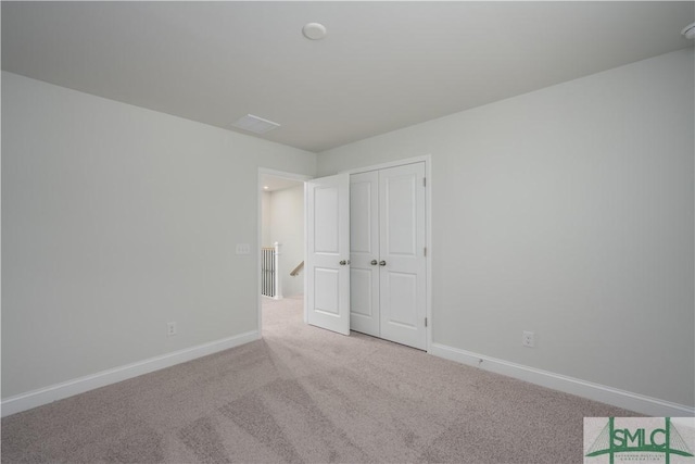 unfurnished bedroom with carpet flooring, baseboards, and a closet