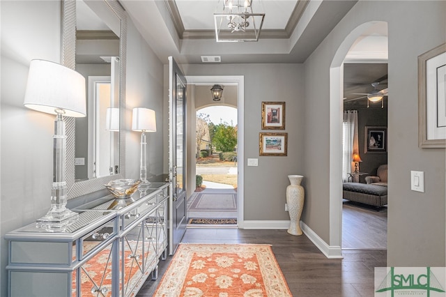 entrance foyer featuring a tray ceiling, ceiling fan, crown molding, and dark hardwood / wood-style flooring