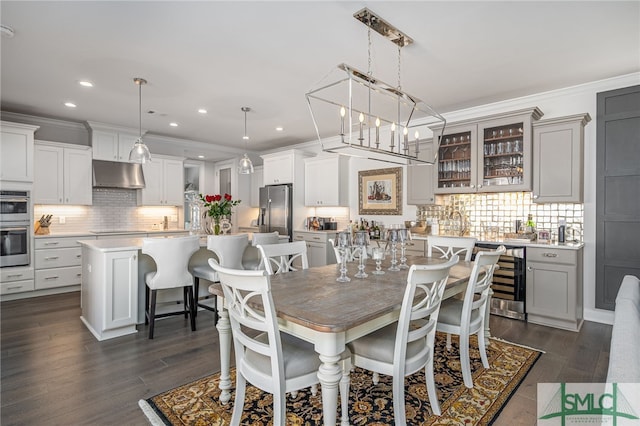 dining room featuring wine cooler, an inviting chandelier, crown molding, and dark wood-type flooring