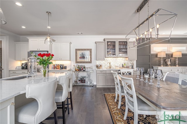 dining area featuring crown molding, dark hardwood / wood-style floors, and sink