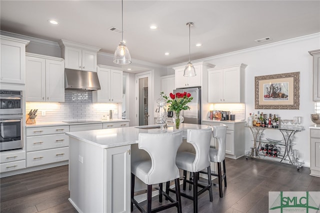 kitchen featuring a center island with sink, stainless steel appliances, white cabinets, and hanging light fixtures