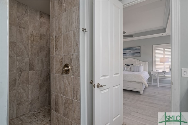 bathroom featuring crown molding, wood-type flooring, and tiled shower