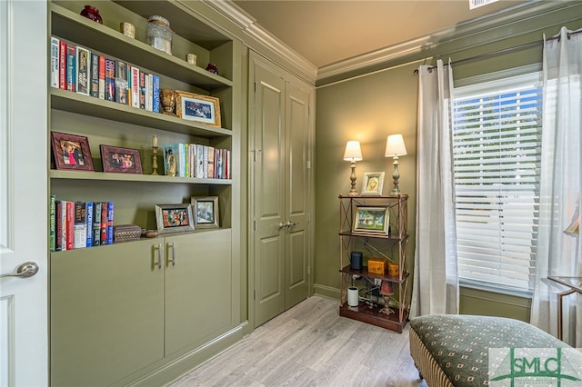 living area featuring ornamental molding and light hardwood / wood-style floors