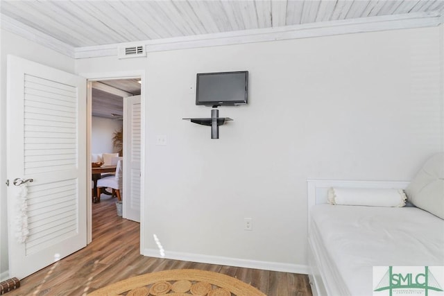 bedroom featuring hardwood / wood-style flooring and crown molding