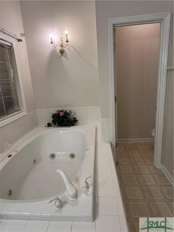 bathroom with tiled tub and toilet