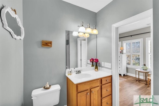 bathroom featuring hardwood / wood-style flooring, toilet, and vanity