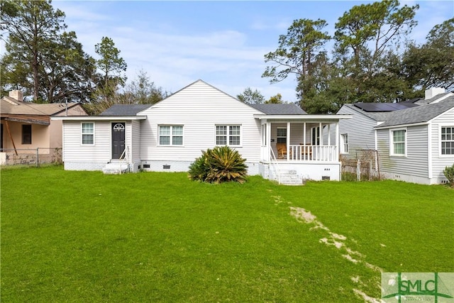 rear view of house featuring covered porch and a yard