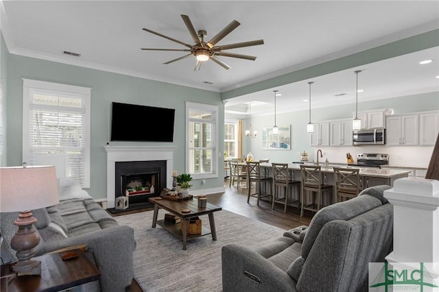 living room with ceiling fan, hardwood / wood-style floors, crown molding, and a healthy amount of sunlight