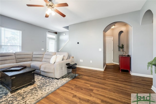 living room featuring ceiling fan and dark hardwood / wood-style floors