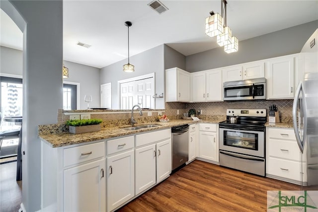 kitchen featuring white cabinetry, sink, stainless steel appliances, and pendant lighting