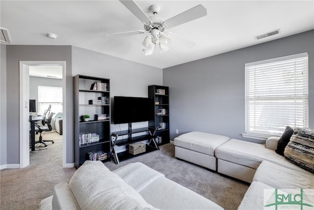 carpeted living room with ceiling fan