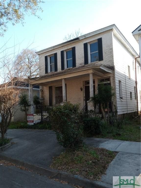 view of front of home with covered porch and brick siding