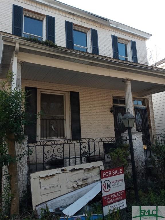 view of front of house with brick siding and a porch