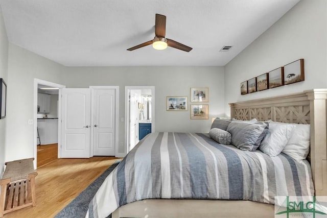 bedroom featuring ensuite bathroom, hardwood / wood-style flooring, and ceiling fan