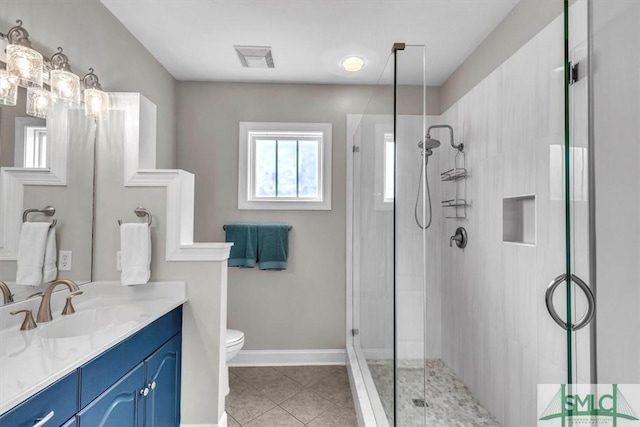 bathroom featuring tile patterned floors, toilet, a shower with door, and vanity