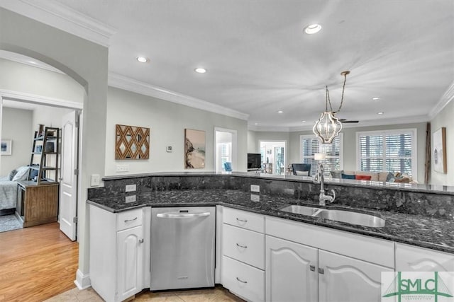 kitchen with stainless steel dishwasher, dark stone countertops, sink, and white cabinets