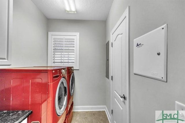 washroom featuring a textured ceiling, light tile patterned flooring, and washer and clothes dryer