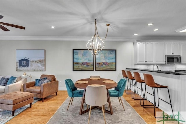 dining space with crown molding and light hardwood / wood-style flooring