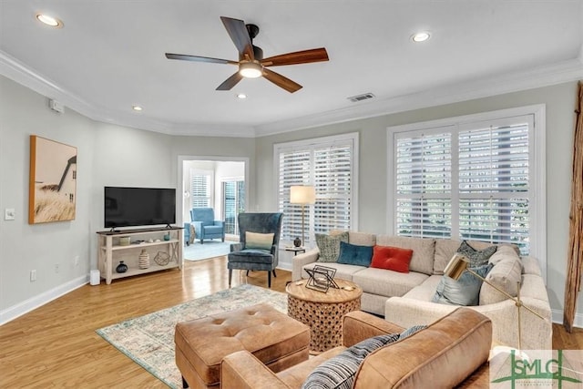 living room featuring ornamental molding, light hardwood / wood-style flooring, and ceiling fan