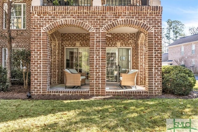 entrance to property featuring a yard and a patio area