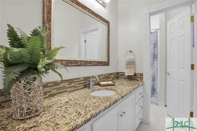 bathroom with vanity, tile patterned flooring, and backsplash