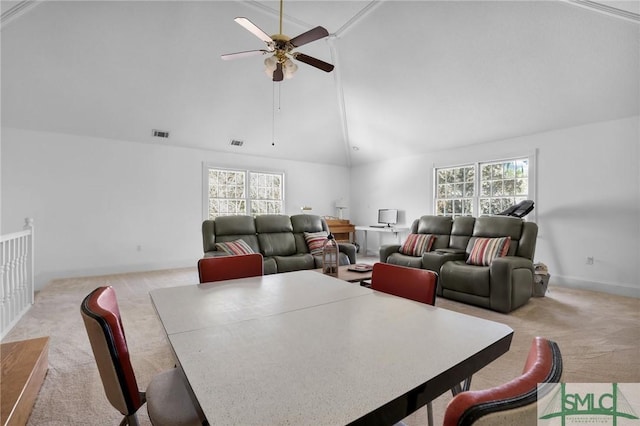 carpeted dining room with ceiling fan, high vaulted ceiling, and a wealth of natural light