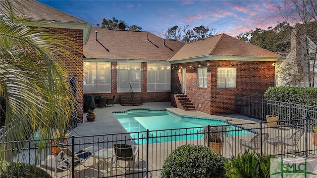 pool at dusk featuring a patio