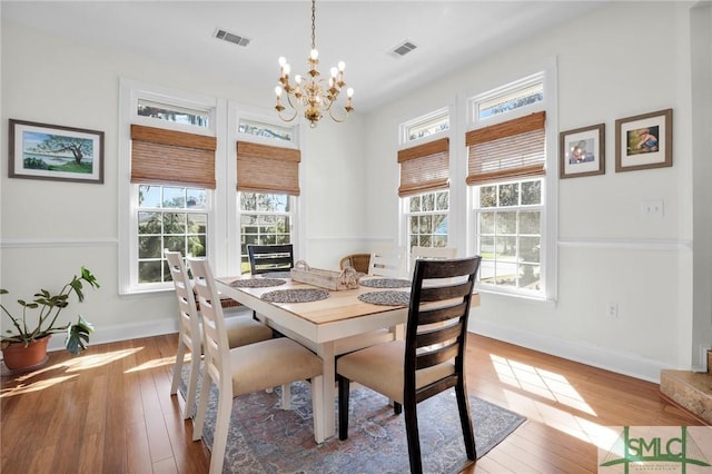 dining room featuring a notable chandelier, light hardwood / wood-style flooring, and a healthy amount of sunlight