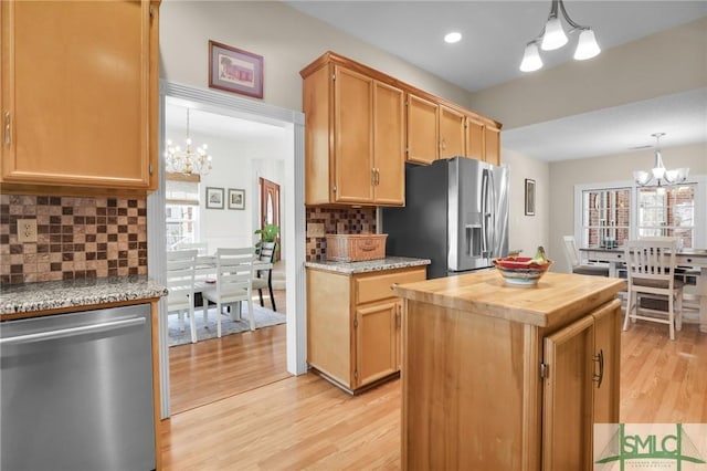 kitchen featuring hanging light fixtures, stainless steel appliances, and a notable chandelier