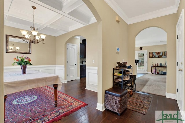 interior space with coffered ceiling, dark hardwood / wood-style flooring, ornamental molding, and beam ceiling