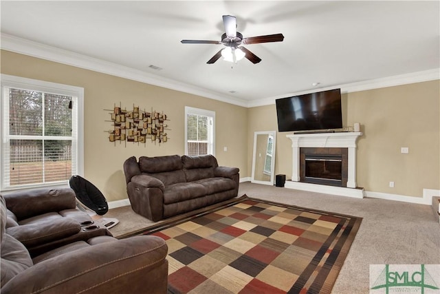 living room with carpet, ornamental molding, and ceiling fan