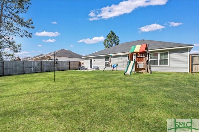 back of property with a playground and a yard