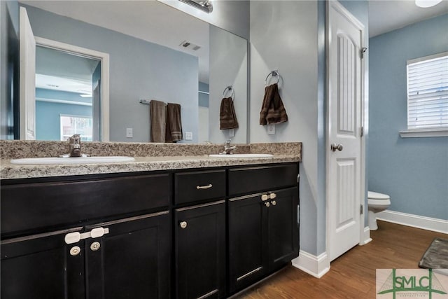 bathroom with toilet, hardwood / wood-style flooring, and vanity