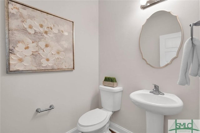 bathroom featuring toilet and baseboards