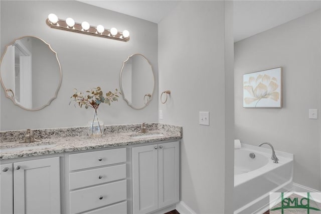 full bathroom featuring a sink, baseboards, and double vanity