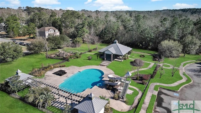 pool with a gazebo, a patio, a lawn, and a view of trees